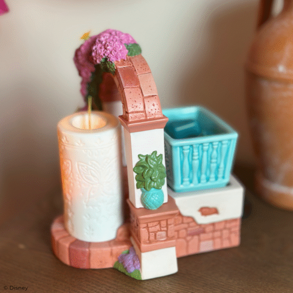 Disney Encanto – Scentsy Warmer Create a fantastical fragrance experience with a Scentsy Warmer inspired by Disney’s Encanto. Featuring nods to La Casa Madrigal and the family’s miracle candle, this stunning décor piece is full of intricate details, from the glimmering butterflies on the dry-brushed bougainvillea flowers to the faux candle’s etched butterfly design and symbolic “flame.” It’s a great addition to any casita!